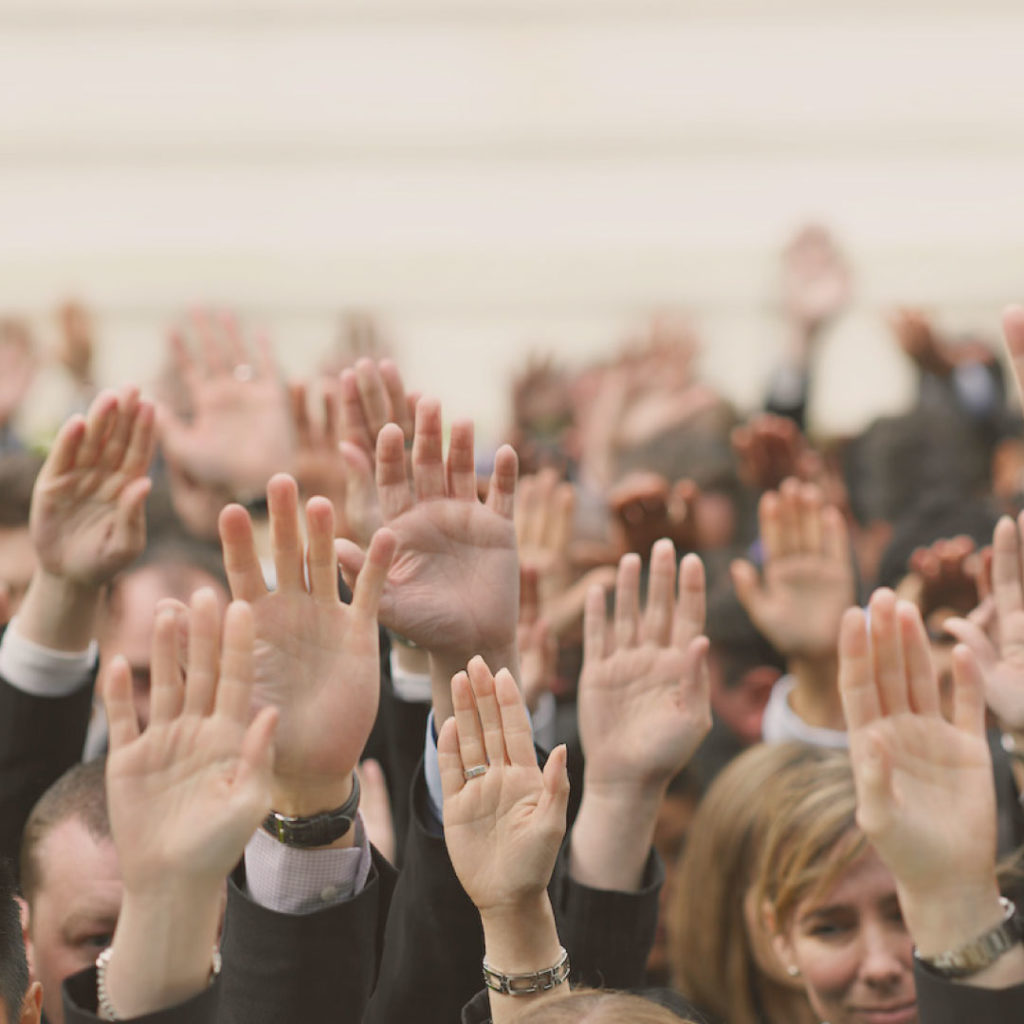 crowd of people raising hands