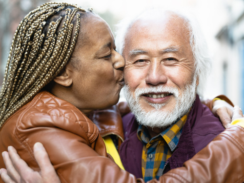 elderly woman kisses elderly man on the cheek