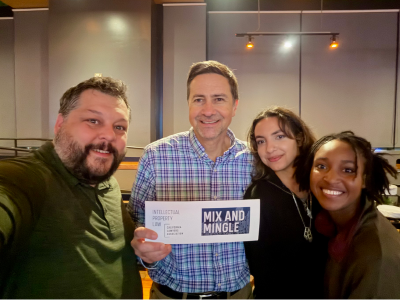 4 attendees posing with Mix & Mingle signage