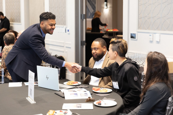 Event attendee and sponsor hand shaking